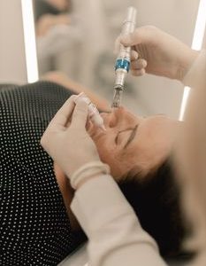 Close-up of person receiving microneedling beauty treatment in a clinic.